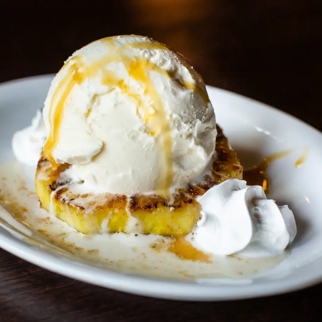 A white plate topped with ice cream and some cake.