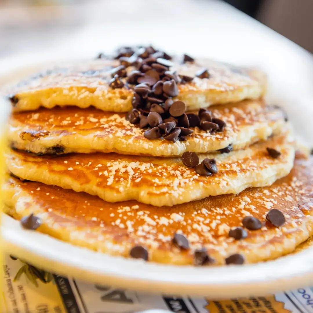 A plate of pancakes with chocolate chips on top.